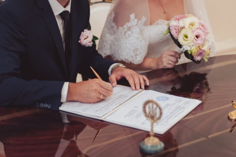 Paar unterschreibt bei der Hochzeit
